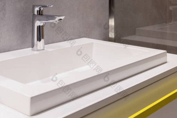 浴室内饰用水龙头和黄色手柄的陶瓷洗脸盆的特写
