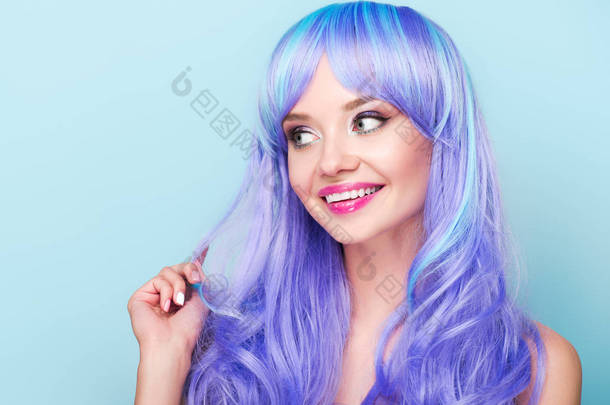 微笑的年轻女子与卷曲的蓝色头发看着<strong>远离</strong>孤立的蓝色