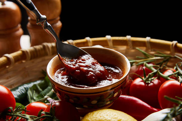 用勺子在新鲜成熟蔬菜旁的美味番茄酱近景
