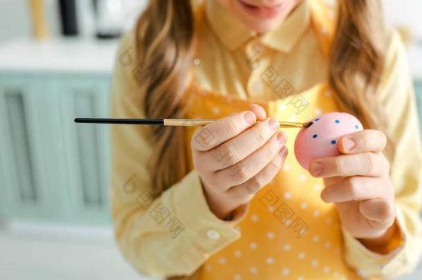 孩子在家用画笔画复活节彩蛋的剪影