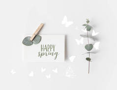 平躺与桉树和纸与快乐的春天刻字在白色表面上