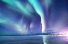 罗弗敦群岛上的北极极光, 挪威。山上的绿色北极光。夜空中的极地灯光。夜间冬季景观与极光和倒影在水面上。自然背景在挪威