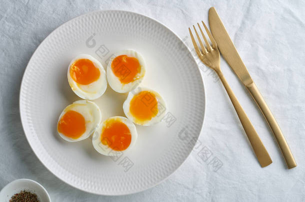 软<strong>煮</strong>熟的<strong>鸡蛋</strong>，剥开后切成两半，放在白盘上