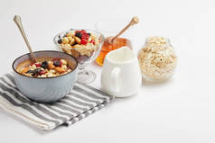 用燕麦片、坚果和浆果在白色桌子上的条纹餐巾纸碗, 有复制空间