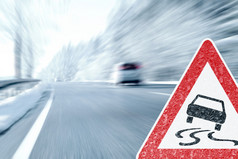 冬季开车-结冰的路面上与警告标志