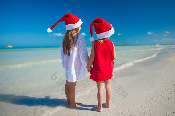 异国情调<strong>海滩</strong>上戴着圣诞帽<strong>的</strong>可爱小女孩SU00A0<strong>的</strong>后视图