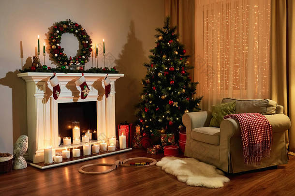 圣诞房间室内设计，圣诞树装饰<strong>彩灯</strong>，赠送玩具，蜡烛和花环照明室内壁炉。圣诞假期客厅。新年设计.