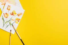 在富有创意的绘画中，画笔上方的图画与黄色的花朵隔离在一起 
