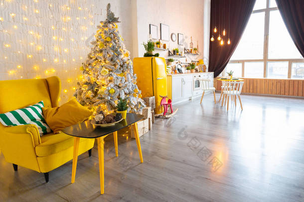 时尚<strong>奢华</strong>室内设计风格斯堪的纳维亚风格的厨房区工作室公寓明亮的黄色家具和装饰与新年树.
