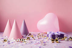 心形气球, 派对帽和紫色桌面上的礼物