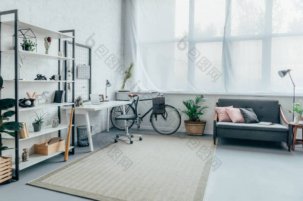 起居室内有自行车、桌子、架子和沙发