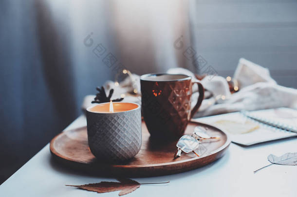 舒适的秋天或冬天的<strong>早晨</strong>在家。静止不动的生活细节与一杯茶，蜡烛，素描书与水族馆和温暖的毛衣。斯堪的纳维亚海格概念