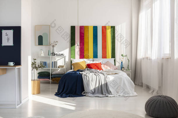 色彩艳丽的卧室内饰有彩虹色的床头