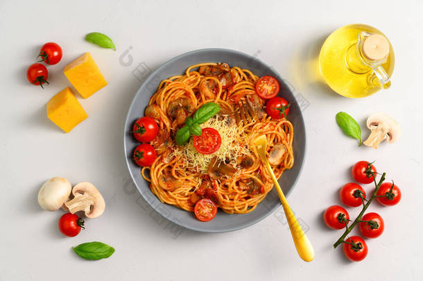 意大利传统烹饪。配上意大利面、番茄酱、樱桃<strong>西红柿</strong>、蘑菇和罗勒的盘子，底色浅灰.