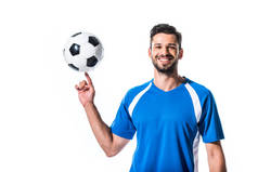 微笑英俊的足球运动员旋转在手指球隔离在白色