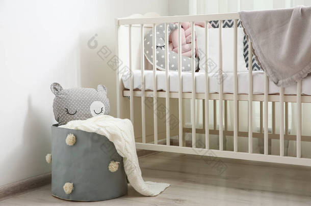 在婴儿房的婴儿床附近装有玩具的篮子。室内设计
