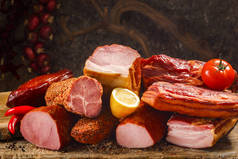各种肉类产品，包括猪肉、牛肉和新鲜蔬菜，放在一张破旧的木制桌子上，背景是深色的