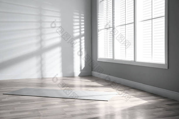 房间地板上展开的灰色<strong>瑜伽垫</strong>