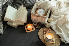 静谧舒适的房子,室内装饰精细.家居用品和舒适。蜡烛和一本书躺在客厅的床上.