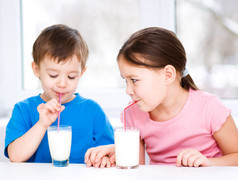 女孩和男孩喝美味新鲜的牛奶