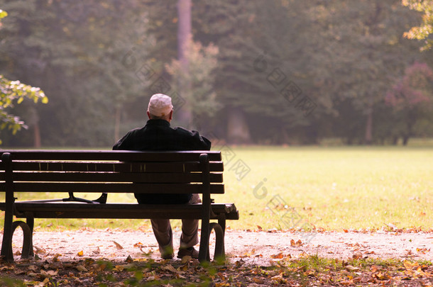 <strong>老人</strong>坐在长椅上，在秋天，秋天的生活