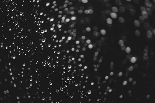 脏窗户玻璃与雨滴。大气单色深色<strong>背景</strong>，散景带雨滴。水滴和污渍特写。宏中的详细透明纹理。复制空间。<strong>雨天</strong>.