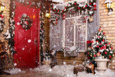 庭院里的圣诞装饰门由喜庆的花环和玩具装饰。窗户上的枞树