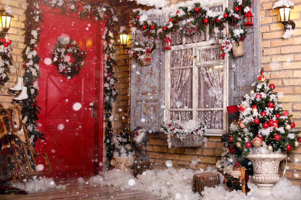 庭院里的<strong>圣诞</strong>装饰门由喜庆的花环和玩具装饰。窗户上的枞树