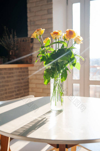 餐厅桌子上的玻璃花瓶里的黄玫瑰。节日和庆祝的概念。圣瓦伦丁日8号马奇和母亲节概念图片