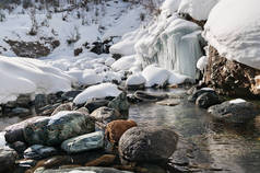 冬季景观的山区河流用石块和冷冻的小瀑布