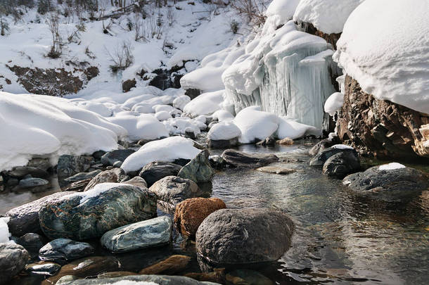 冬季景观的山区河流用石块和冷冻的小瀑布