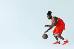 英俊的非洲裔美国运动员在灰色背景上打篮球,复制空间