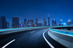 弯曲的天桥高速公路前进的道路与曼谷城市景观夜景。运动模糊效果适用