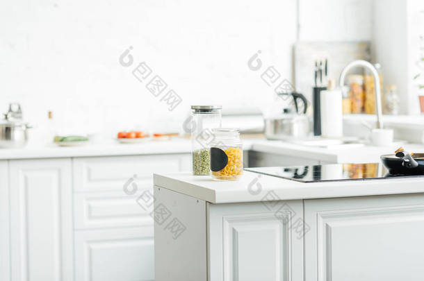 空的现代白色厨房的内部与罐子在桌上