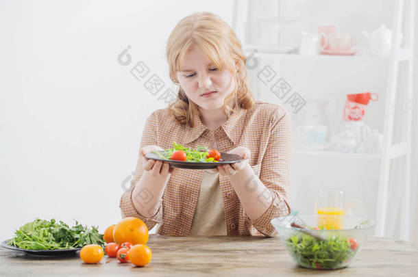 青少年女孩在饮食吃沙拉板