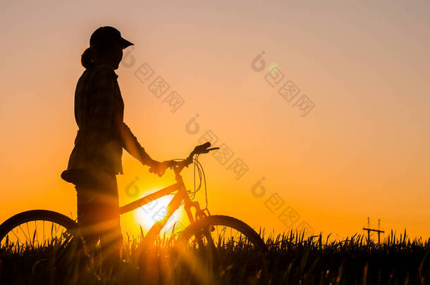 骑自行车的女人欣赏日落