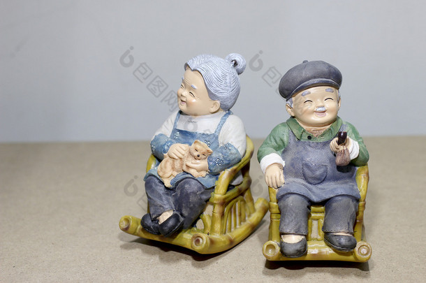 可爱的祖父母或外祖父母娃娃选址摇摆的竹椅上木背景。-静物.