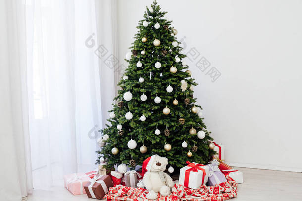 圣诞室内的白色房间，绿树成荫，装饰着红色的圣诞礼物，准备过年过冬