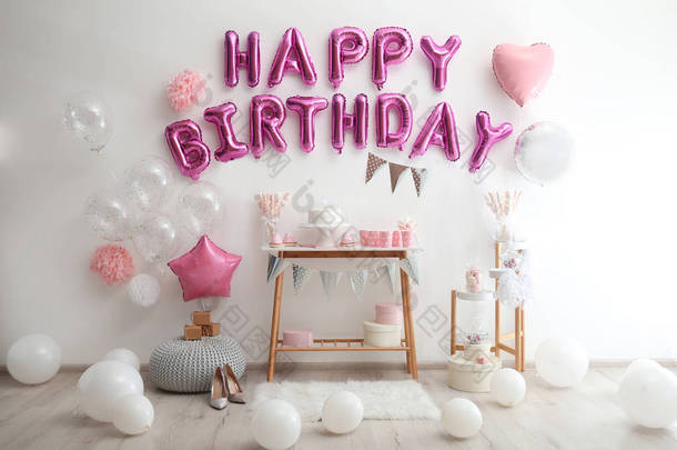 在装饰过的房间里用粉色气球写的生日快乐信