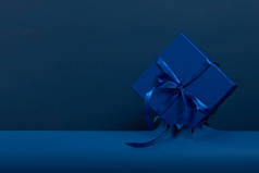 蓝色礼品盒，蓝色包装纸背面有蝴蝶结