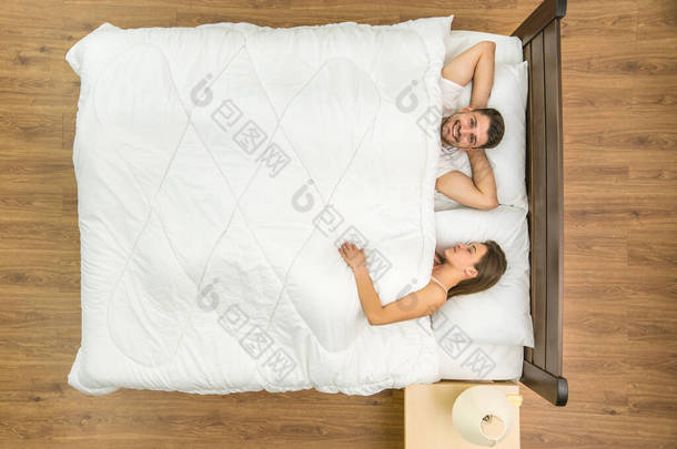 这对夫妇躺在床上。从上面看