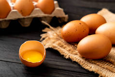 木桌上的棕色鸡蛋, 一个破碎的鸡蛋和蛋黄