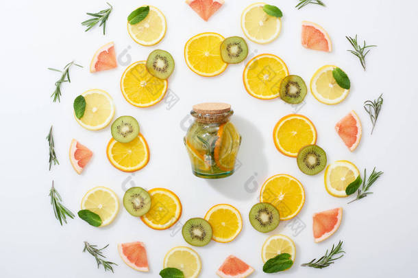 在灰色背景的罐子里, 可以看到猕猴桃、橙子、柠檬、葡萄柚、薄荷、迷迭香和排毒饮料的顶视图