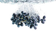 一束红葡萄在水的背景上溅成晶莹清澈的水.健康食品