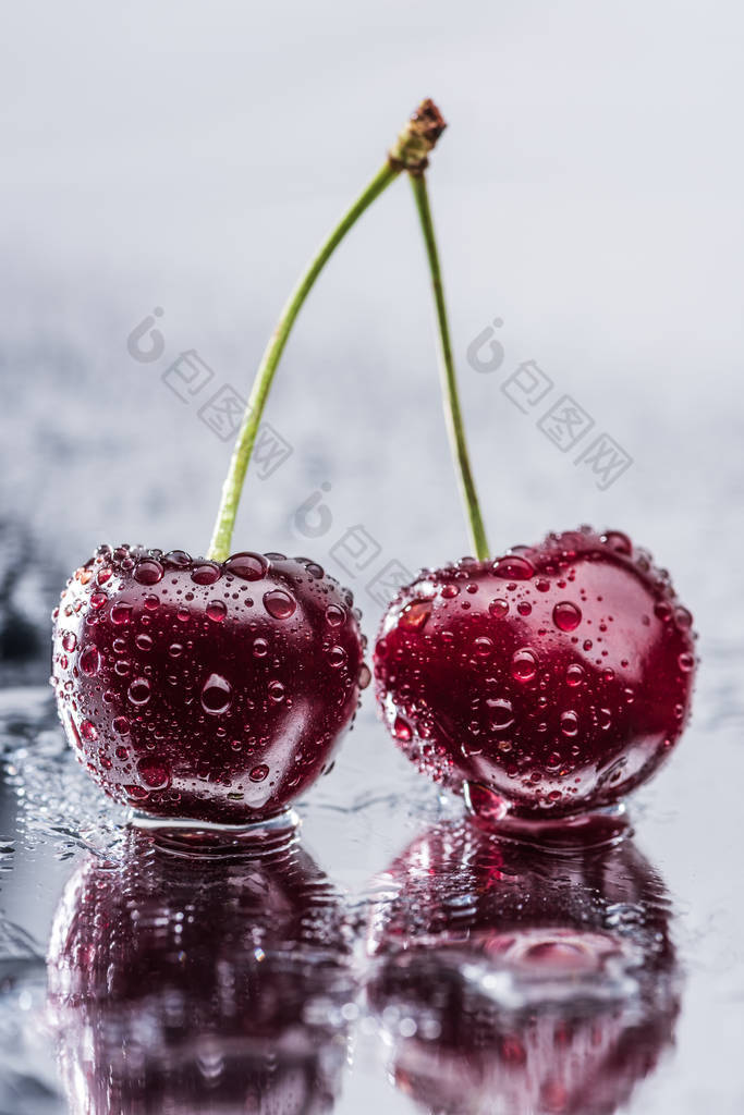 红色成熟樱桃在湿表面滴水的特写观察 