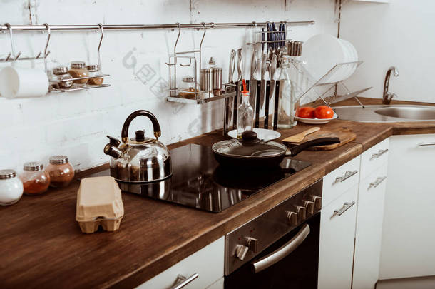 现代化的厨房内饰, 炉灶上有煎锅和茶壶 