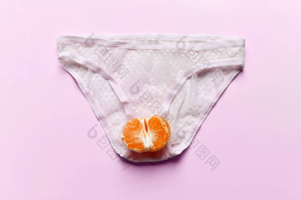 身体护理妇科和妇女的健康。女人的内裤和一半的橘果在一个亲密的部分