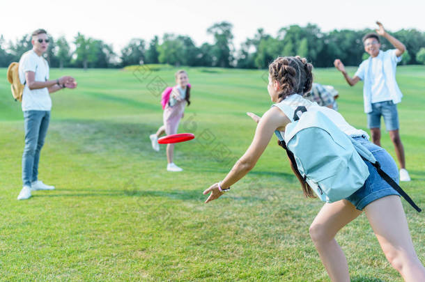 快乐的多民族<strong>青少年</strong>朋友玩飞碟在公园
