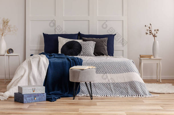 灰色和蓝色的床上用品和毯子在舒适的特大号床