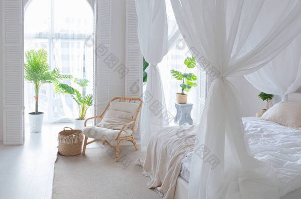 舒适的内部，有明亮的巴厘风格的公寓和完全白色的墙壁，柳条家具